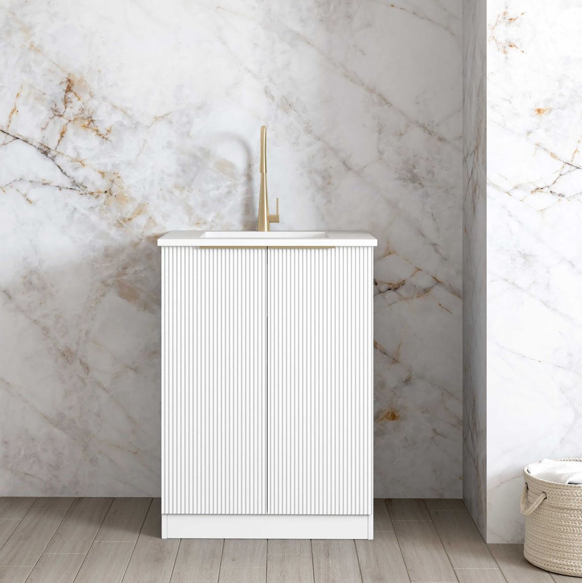 A white mini laundry cabinet with a stone top and a stainless steel sink, featuring soft closing doors and bar handle in brushed gold.
